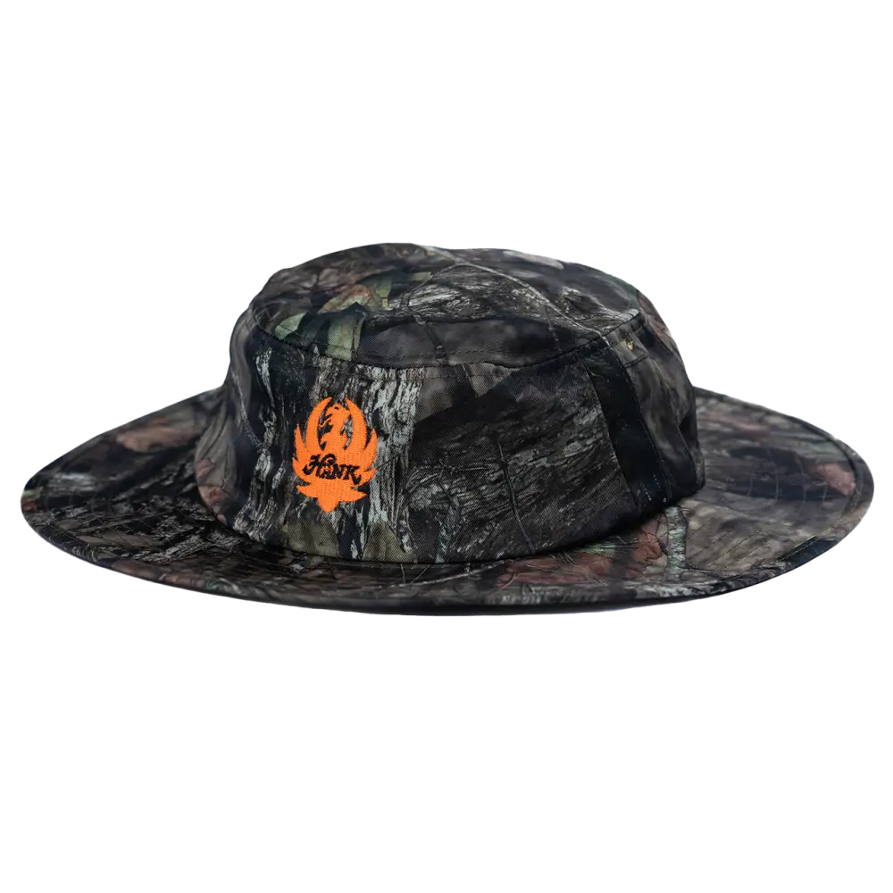 Camouflage-patterned wide-brimmed hat with an orange logo.