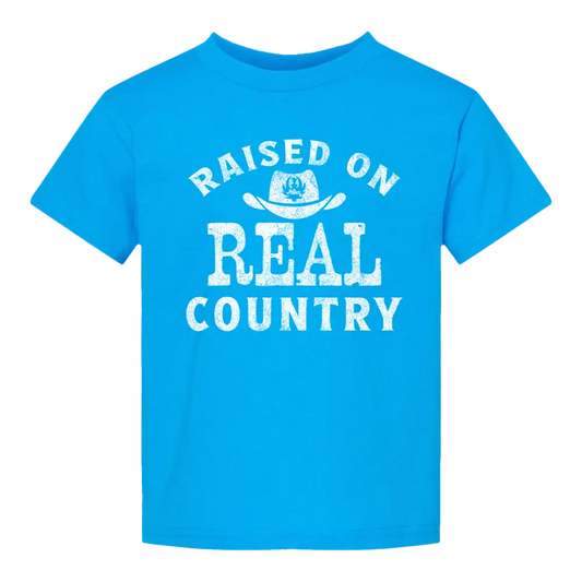 Blue t-shirt with ’Raised on Real Country’ text.