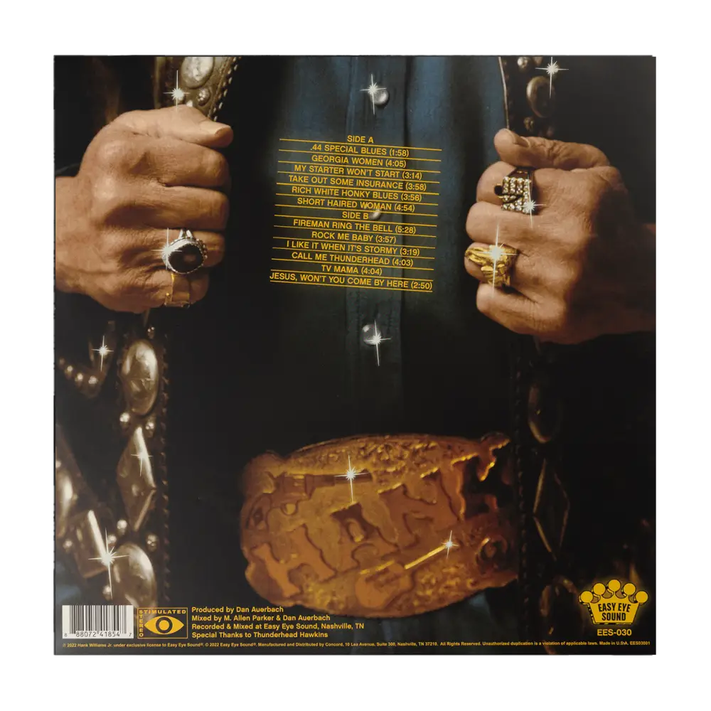 Album cover featuring hands wearing multiple rings and a golden object resembling a crown or burger.