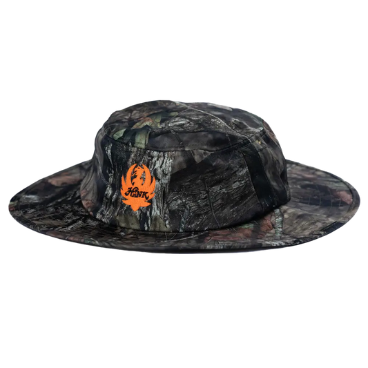 Camouflage-patterned wide-brimmed hat with an orange logo.