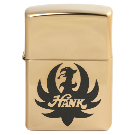 Gold-colored Zippo lighter with a black eagle logo and the name ’Hank’ engraved on it.