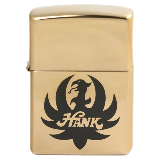 Gold-colored Zippo lighter with a black eagle logo and the name ’Hank’ engraved on it.